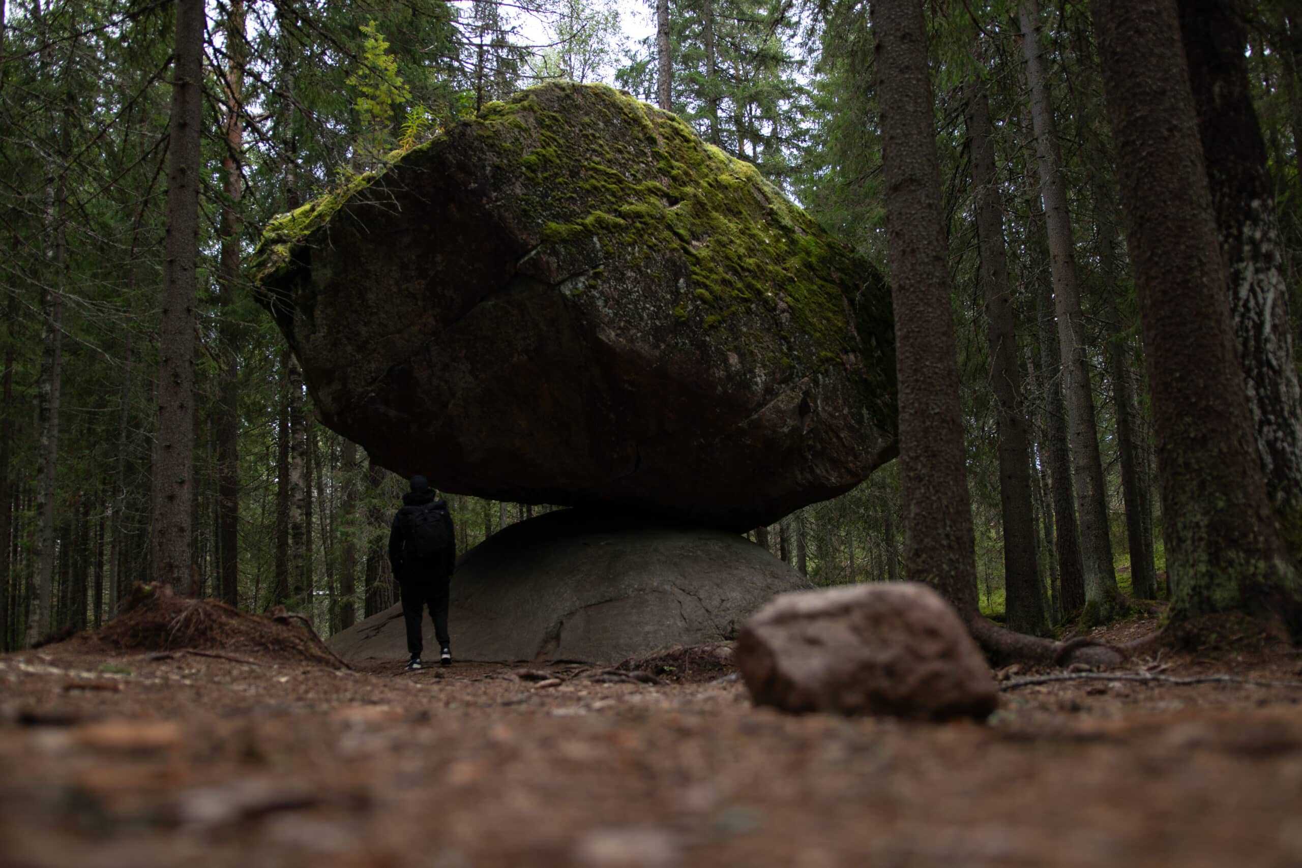 Person neben Kummakivi im finnischen Wald - Finnland Rundreise