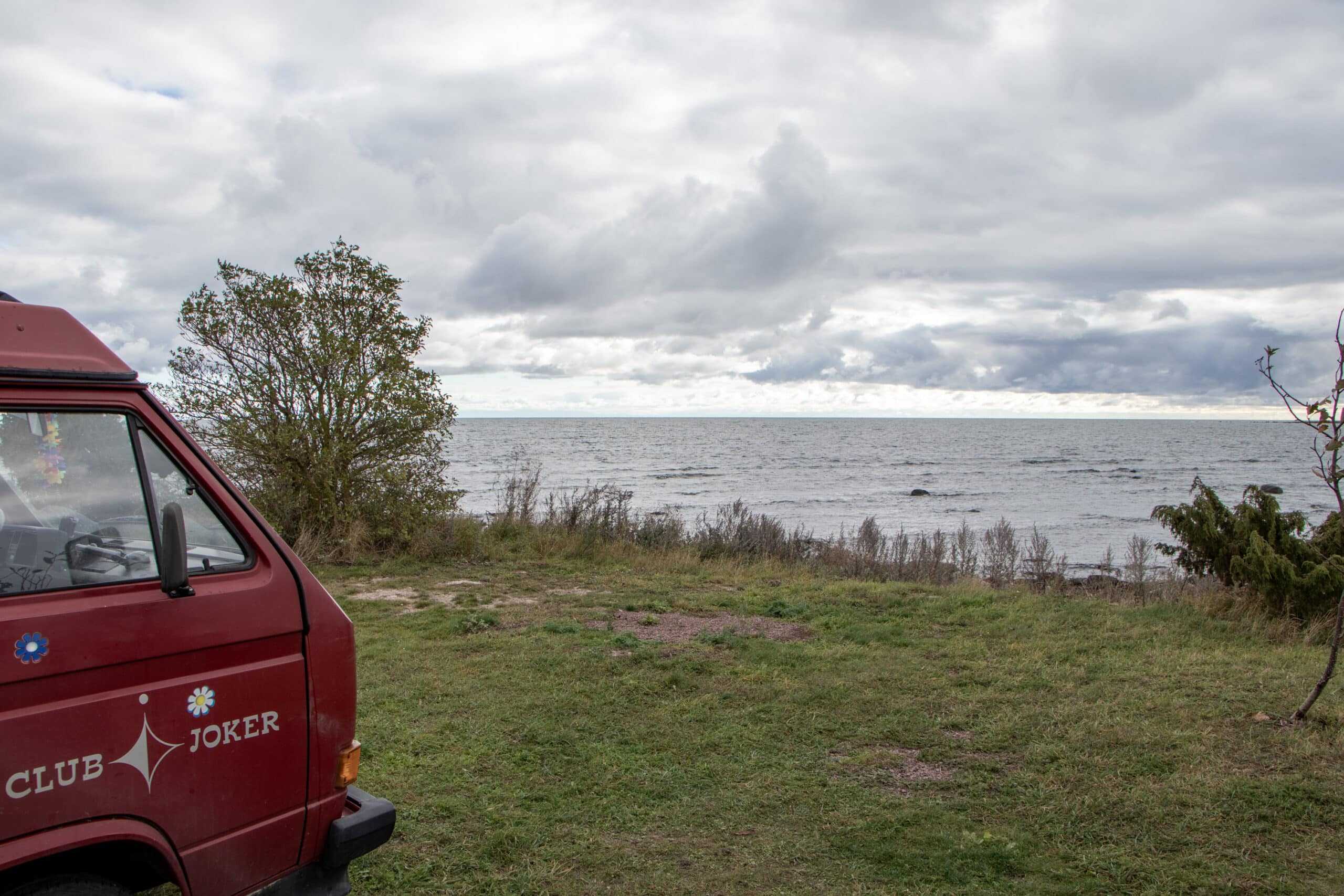 Roter Camper am Meer bei bewölktem Himmel – Schweden Roadtrip