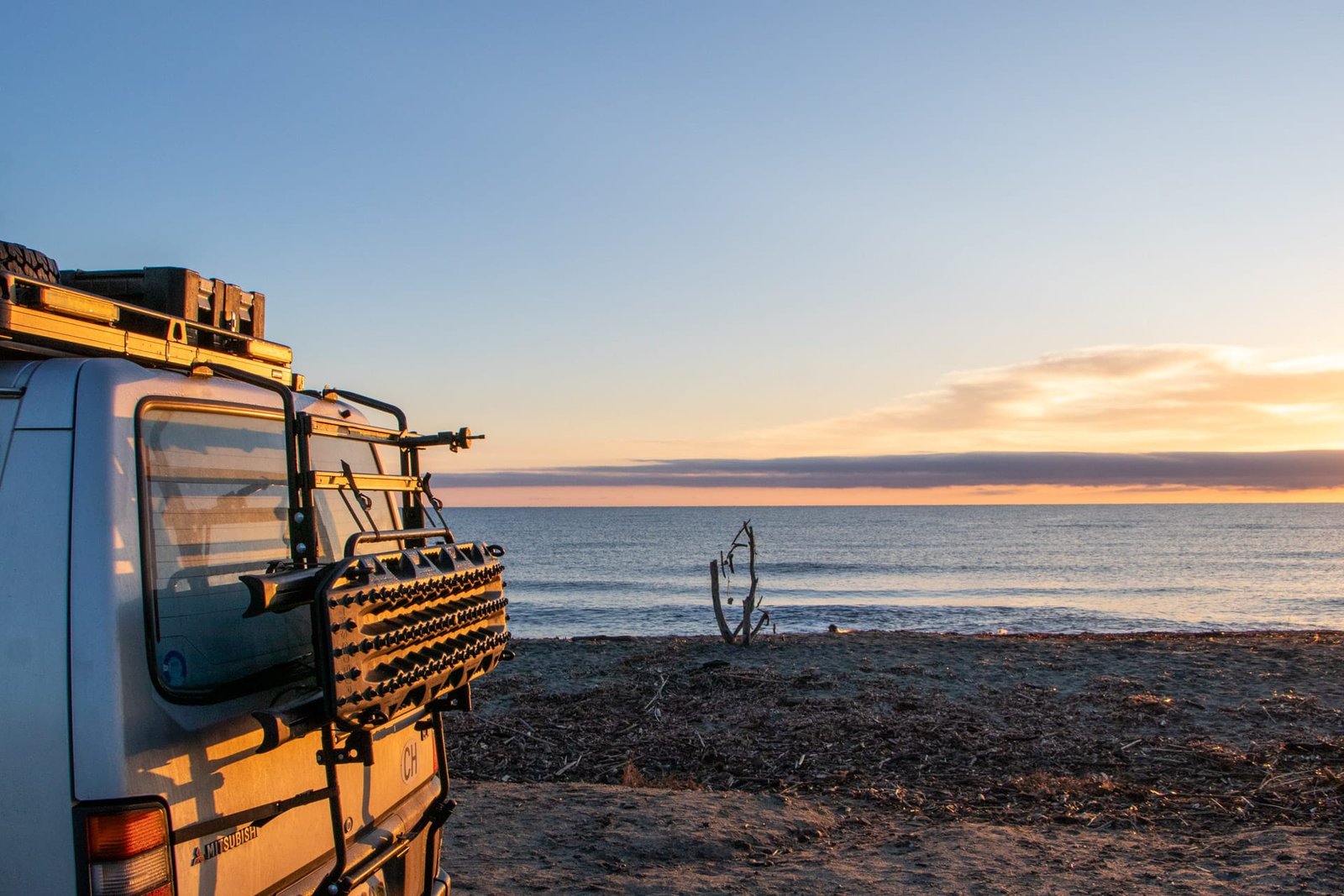 Camper am Strand in Korsika bei Sonnenuntergang