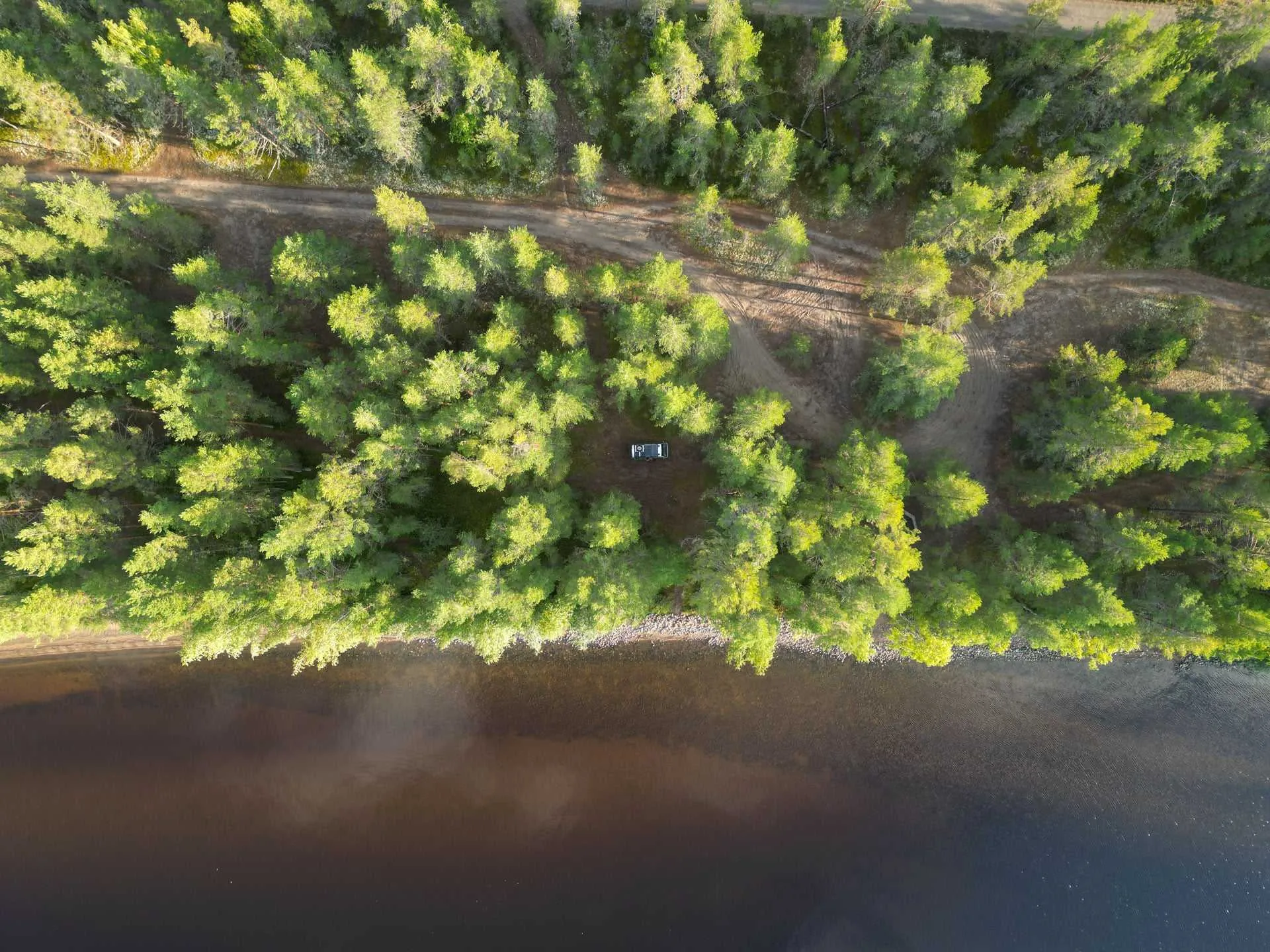 Luftaufnahme von Camper im Wald am Seeufer - Finnland Rundreise